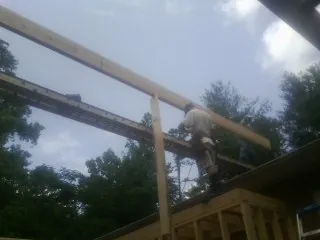 Carpenter setting a ridge beam over a new addition frame — Ice Dam Removal by Roofing Brothers in Colbert